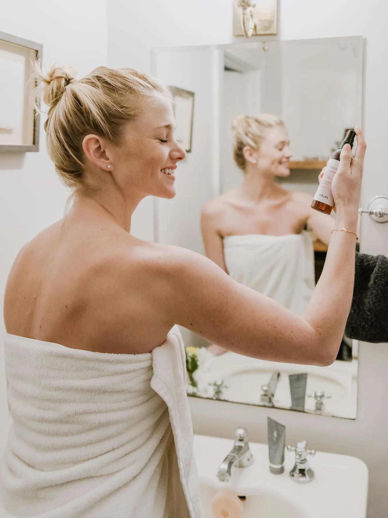 Photograph of a woman caring for her skin at a mirror, by Kalos Skincare