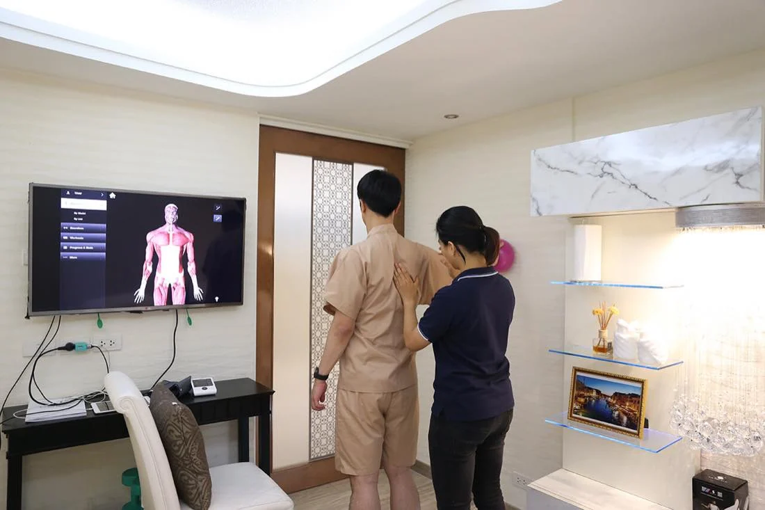 A clinician assessing a standing visitor beside a movement display.