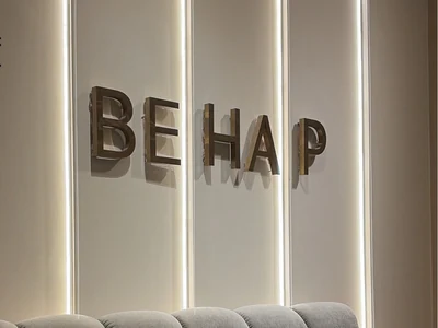 BEHAP wall sign above a grey sofa.
