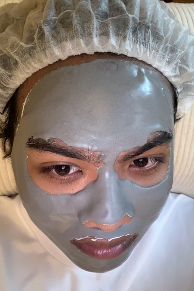 A person wearing a facial mask and disposable hair cover.