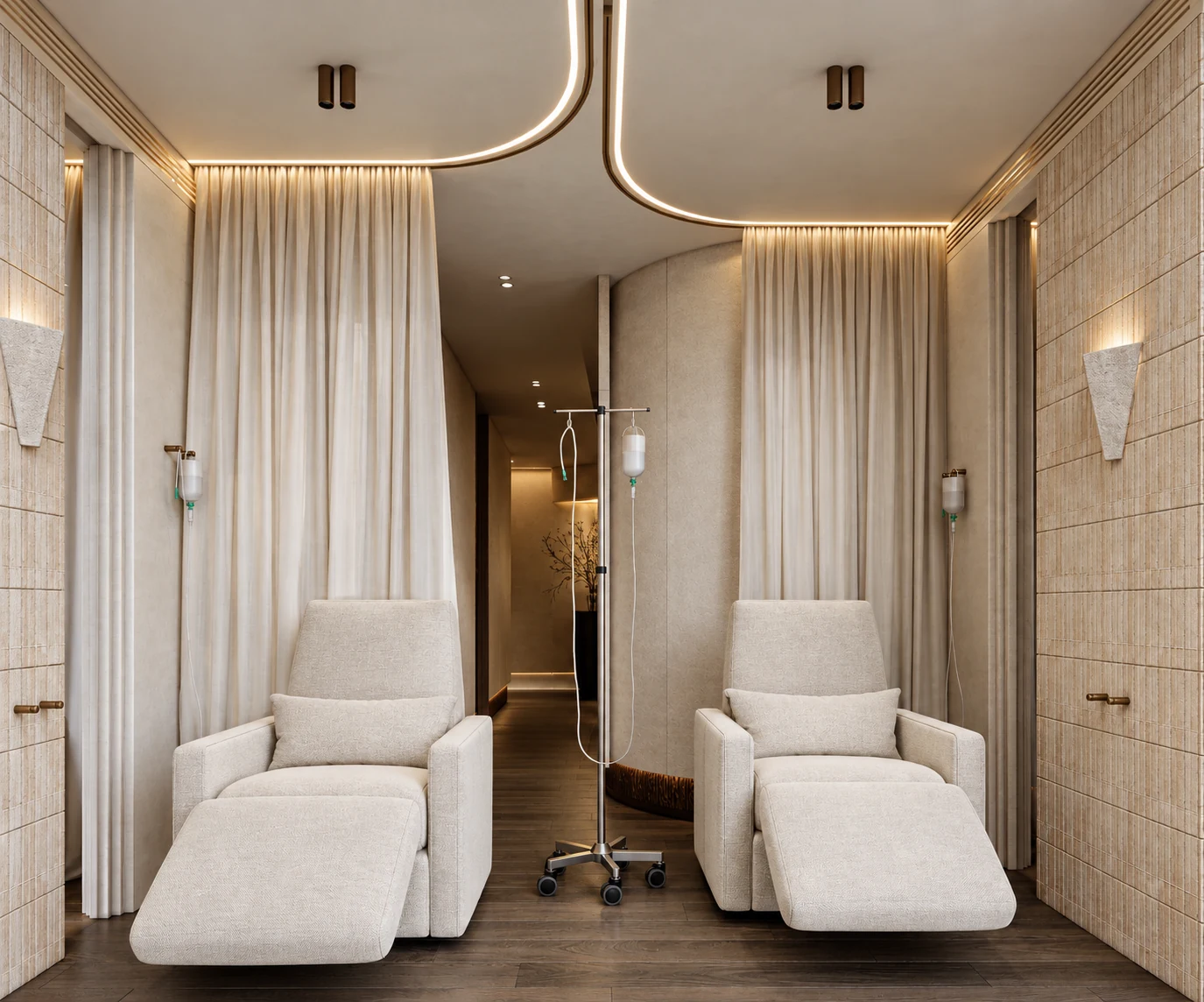Two reclining chairs with curtains and IV stands in a warm-toned clinic room